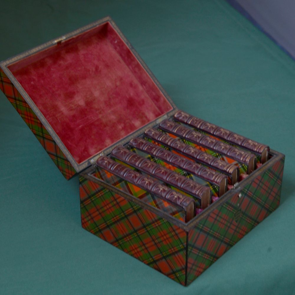 open box showing 6 books enclosed with leather spines and tartanware designs on the front and back covers