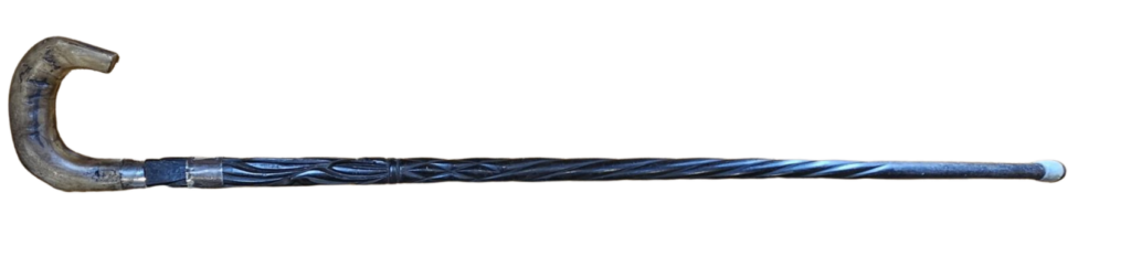 wooden walking stick with curved handle made from horn and banded metal at the top of the stick