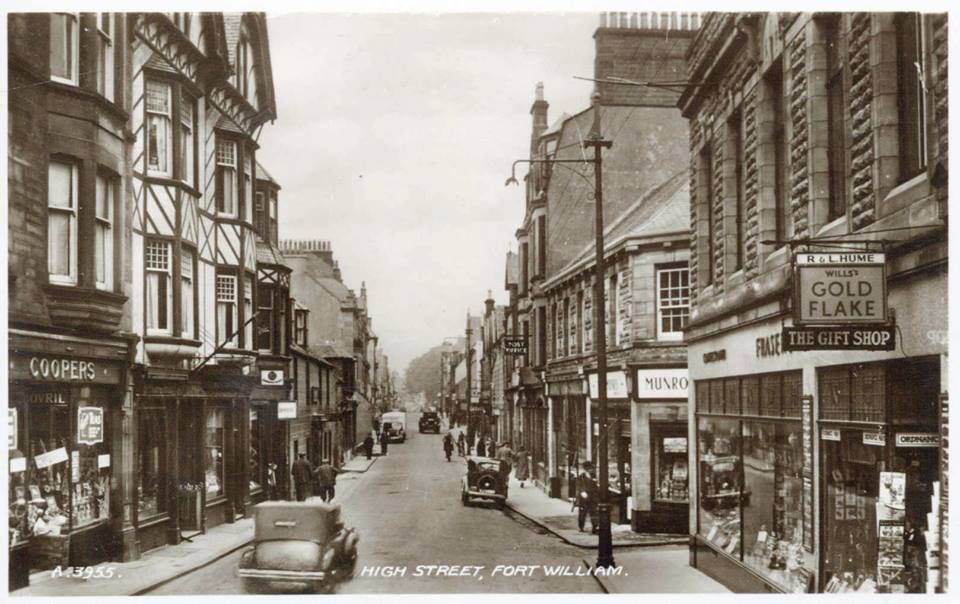 Black and white photographic image of a street with an old fashioned car
