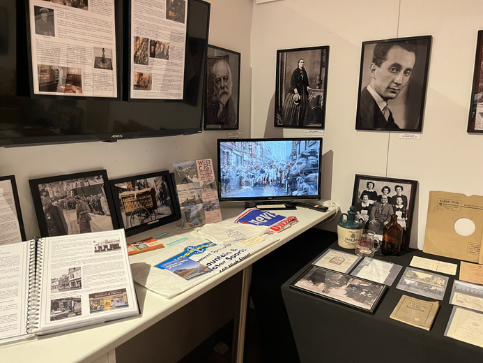 A video screen showing old postcards with written material displayed nearby